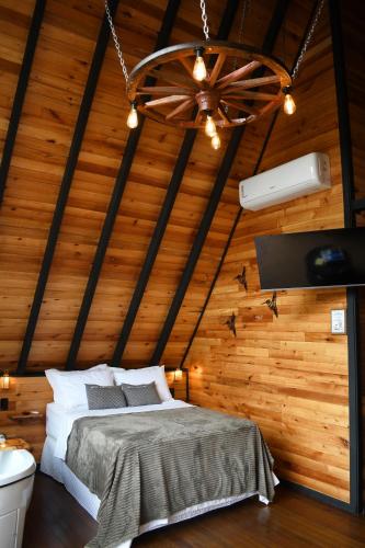 a bedroom with a bed and a ceiling fan at Chalé Encanto Do Lago in Urubici