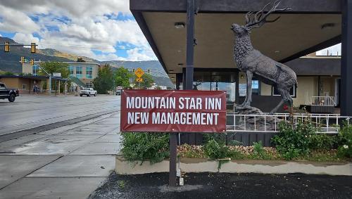 a sign for a mountain star inn with a deer statue at Mountain Star Inn Cedar City in Cedar City