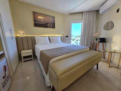 a hotel room with a bed and a balcony at Jatobá Praia Hotel in Aracaju