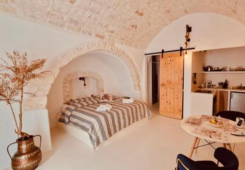 a bedroom with a bed and a table in a room at CASA FLAMÌ 2 in Ostuni