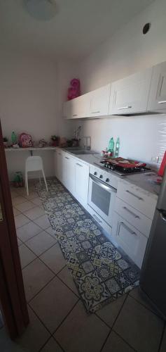 a kitchen with white cabinets and a stove at Caty House in Nettuno