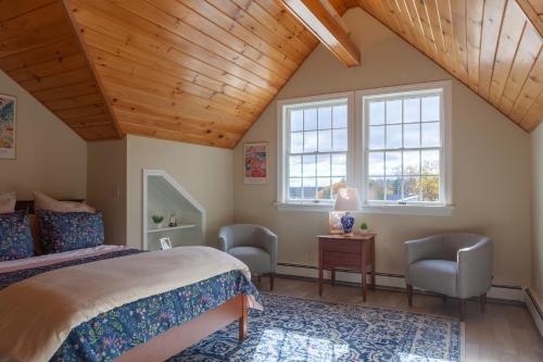 a bedroom with a bed and two chairs at The Manor Bed and Breakfast in Newcastle