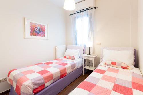 a bedroom with two beds and a window at Iliodysi Houses in Methoni
