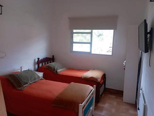 a small room with two beds and a window at Rincon Del Colibri in Reyes