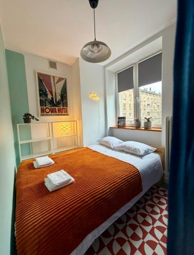 a bedroom with a bed with two towels on it at Lovely Jubbly Apartment in Krakow