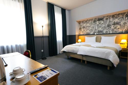 a hotel room with a large bed and a desk at Gartner Hotel in Budapest