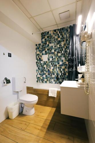 a bathroom with a toilet and a tub and a sink at Gartner Hotel in Budapest