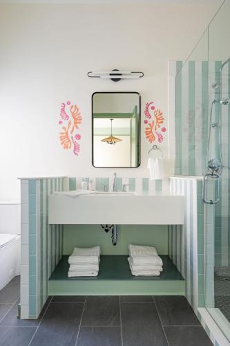 a bathroom with a sink and a mirror at The Pass Bungalows in Pass Christian