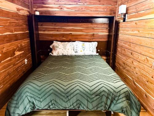 a bedroom with a bed in a log cabin at Treehouse by the Creek in Walland