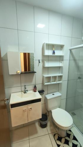 a white bathroom with a toilet and a sink at Refúgio perfeito em Itatiba in Itatiba