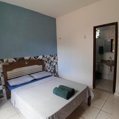 a bedroom with a bed with a green towel on it at Casa Relva Suítes in Lençóis