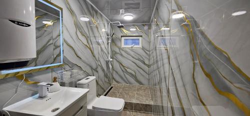 a bathroom with a white toilet and a sink at Arista Yurt Camp in Karakol