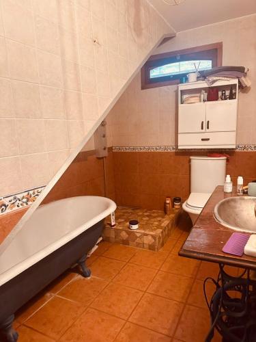 a bathroom with a tub and a toilet and a sink at Posada Bella Vista 1 y 2 in El Volcán