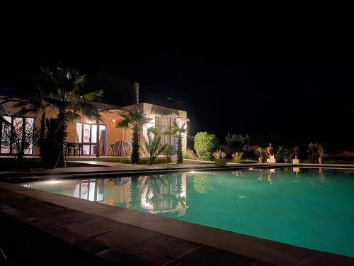 a swimming pool in front of a house at night at La Perle d'Argan in Essaouira