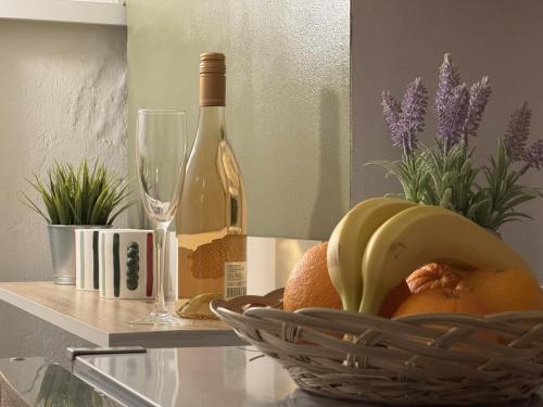 a basket of fruit and a bottle of wine on a table at Vanito Art Escape in Nesebar