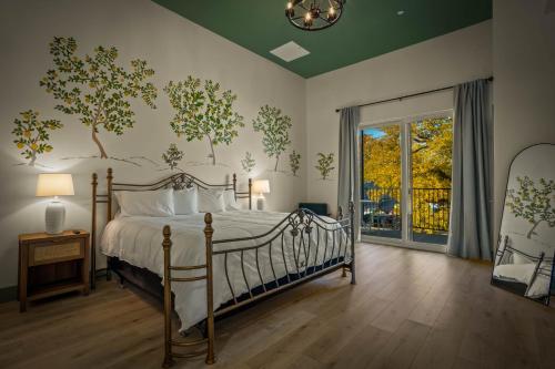 a bedroom with a bed with trees on the wall at Hotel Mojo in Ocean Springs