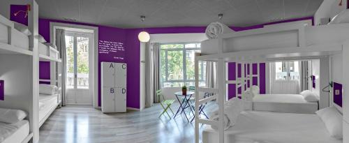 a bedroom with purple walls and white bunk beds at Safestay Madrid Central in Madrid