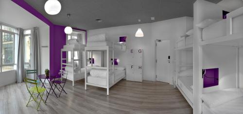 a bedroom with white bunk beds and purple walls at Safestay Madrid Central in Madrid