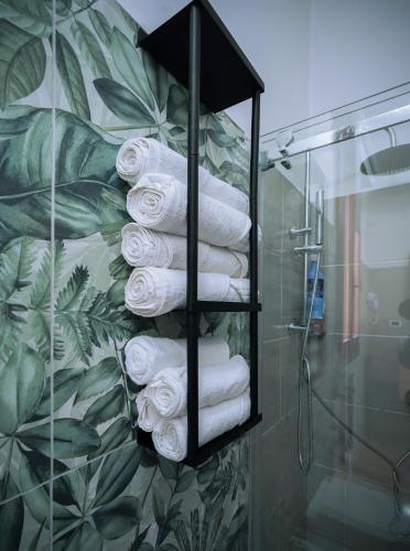a bunch of towels in a towel rack in a bathroom at The Ngatchou in Mestre