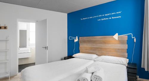 a bedroom with a bed with a blue wall at Safestay Madrid Central in Madrid