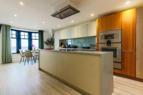 a large kitchen with a large island in a room at Beachcliff Rooms & Apartments in Cardiff