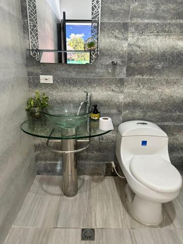 a bathroom with a toilet and a glass sink at APARTAMENTO CONFORTABLe 200 in Arauca