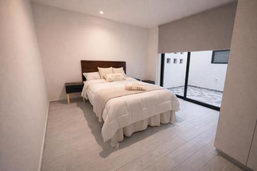 a bedroom with a large bed and a large window at Quiet Private Room in El Pueblito