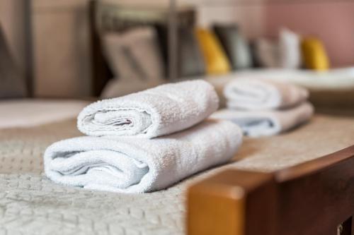 a pile of towels sitting on top of a bed at 2BR House with WiFi - Sleeps 5 - Gloucester in Gloucestershire