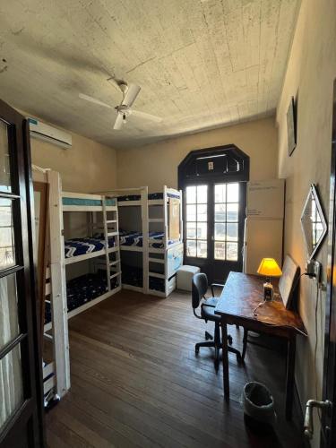 a room with bunk beds and a desk and a table at Republica Hostel in San Pedro