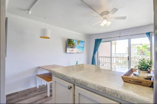 a kitchen with a table and a ceiling fan at Ocean & Pool View - Hot Tub - 2 Pools - Gym - Tennis ct - Shoreline Stays 10 in Galveston