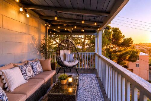a porch with a couch and a chair on a balcony at CasaViva Vista - Top-Floor 2BR with Private Porch, City Views & Sunset, Walk to Hillcrest, Near Zoo & Beaches, San Diego in San Diego