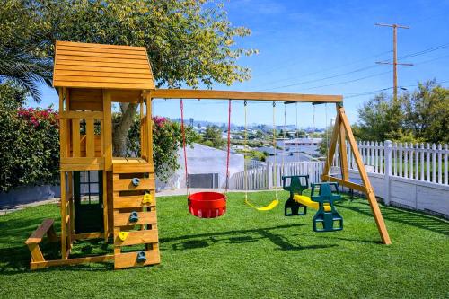 a wooden playground with a swing and a swing at CasaViva Vista - Top-Floor 2BR with Private Porch, City Views & Sunset, Walk to Hillcrest, Near Zoo & Beaches, San Diego in San Diego