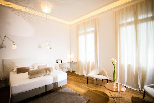 a white living room with a couch and a table at L'Hôtel Particulier Beziers in Béziers