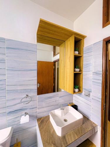 a bathroom with a sink and a mirror at Diani hideouts in Kwale