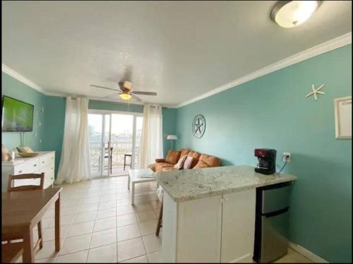 a kitchen and living room with a couch and a table at Ocean Views - Heated Pool - Hot Tub - Corner Unit - steps to beach - SS 29 in Galveston