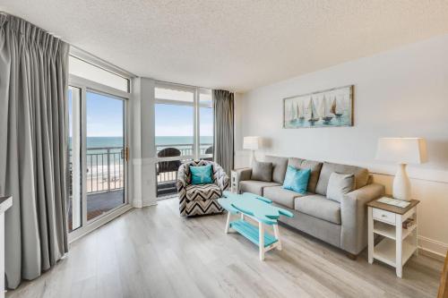 a living room with a couch and a table at NEW Baywatch Remodled with Direct Oceanfront Views in Myrtle Beach