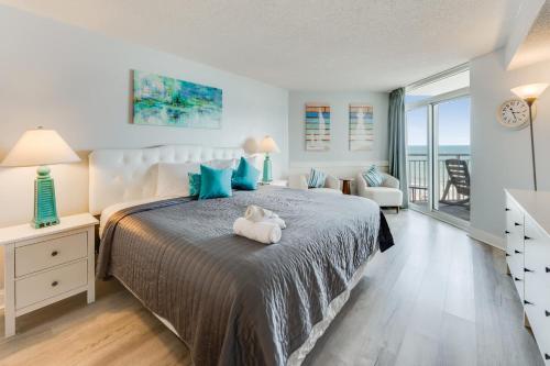 a bedroom with a bed with a teddy bear on it at NEW Baywatch Remodled with Direct Oceanfront Views in Myrtle Beach