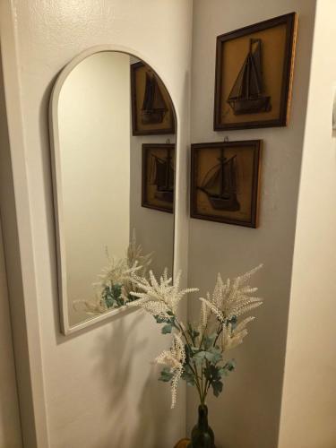 a bathroom with a mirror and a vase with flowers at Olivos Calm Stay in Olivos