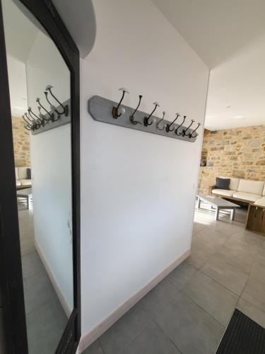 a room with a white wall with a large mirror at La Forge, gîte familial,à Sainte Mère Eglise in Sainte-Mère-Église