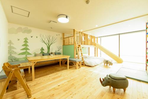 a childs room with a wooden desk and a playroom with a tree mural at Goen Little hatchi 子供が喜ぶ隠れ家宿 in Iwaki