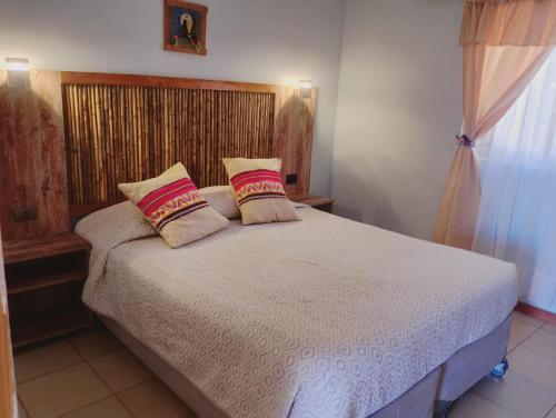 a bedroom with a bed with two pillows on it at Cabañas rústico in San Pedro de Atacama