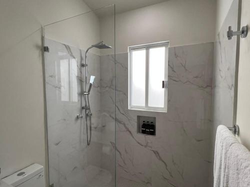 a bathroom with a shower with a glass door at El Encanto Inn & Suites in San José del Cabo