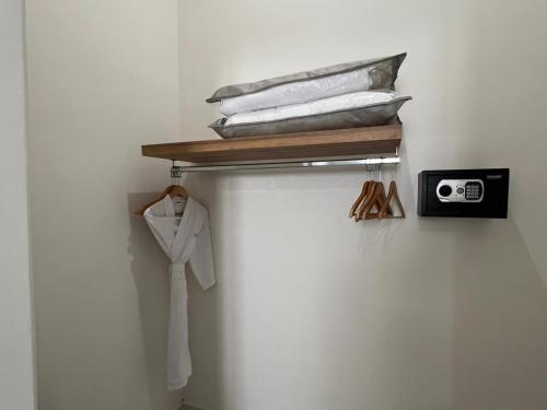 a shelf with a white shirt and a clock on a wall at El Encanto Inn & Suites in San José del Cabo