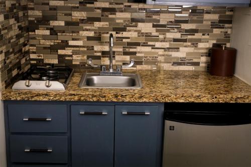 a kitchen counter with a sink and a stove at Business Hotel & Suites María Bonita in Ciudad Juárez