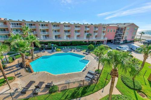 an aerial view of a resort with a pool and palm trees at Ocean & Pool View - Top Floor - 2 Pools - Hot Tub - GYM - Tennis ct - SS03 in Galveston