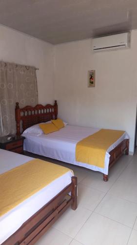 a room with two beds in a room at Posada la Melosa in Guataquí