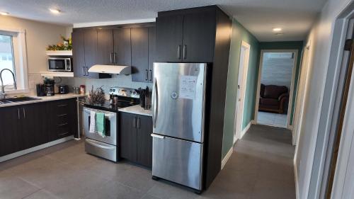 a kitchen with a stainless steel refrigerator in it at Logis des prodiges - Le 777 in Rouyn-Noranda