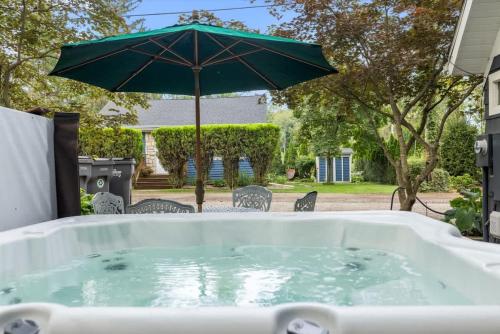 a hot tub with an umbrella in a yard at The Songbird by Juniper Holiday + Home in New Buffalo