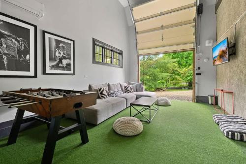a living room with a ping pong table in it at Black Door Bungalow by Juniper Holiday + Home in Lakeside