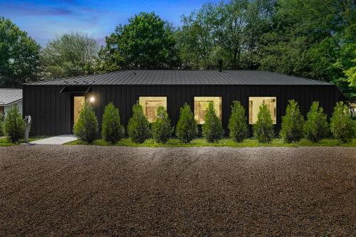 a black house with a black roof at Owlwood by Juniper Holiday + Home in Harbert